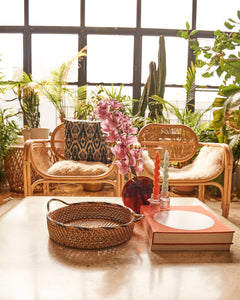 A living room setting showing rattan armchairs and a coffee table
